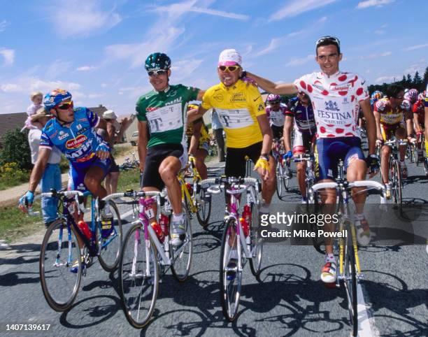 Tour de France leader Jan Ullrich from Germany and Team Telekom cycling team wearing the race leaders yellow jersey rides surrounded by the green...