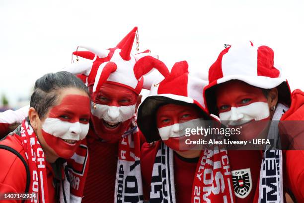 Austria fans wearing hats and face paint pose for a photo outside the stadium prior to the UEFA Women's Euro 2022 group A match between England and...