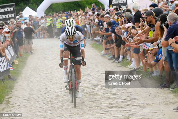 Maximilian Schachmann of Germany and Team Bora - Hansgrohe competes passing through a cobblestones sector while fans cheer during the 109th Tour de...