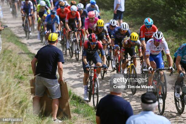 Dylan Van Baarle of Netherlands and Team INEOS Grenadiers and Daniel Oss of Italy and Team Total Energies compete passing through a cobblestones...