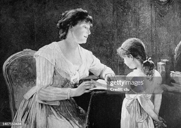 mother teaches daughter at the table, pointing at a book - kids study table stock illustrations