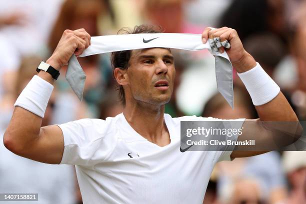 Rafael Nadal of Spain places a headband on his head during a break against Taylor Fritz of The United States during their Men's Singles Quarter Final...