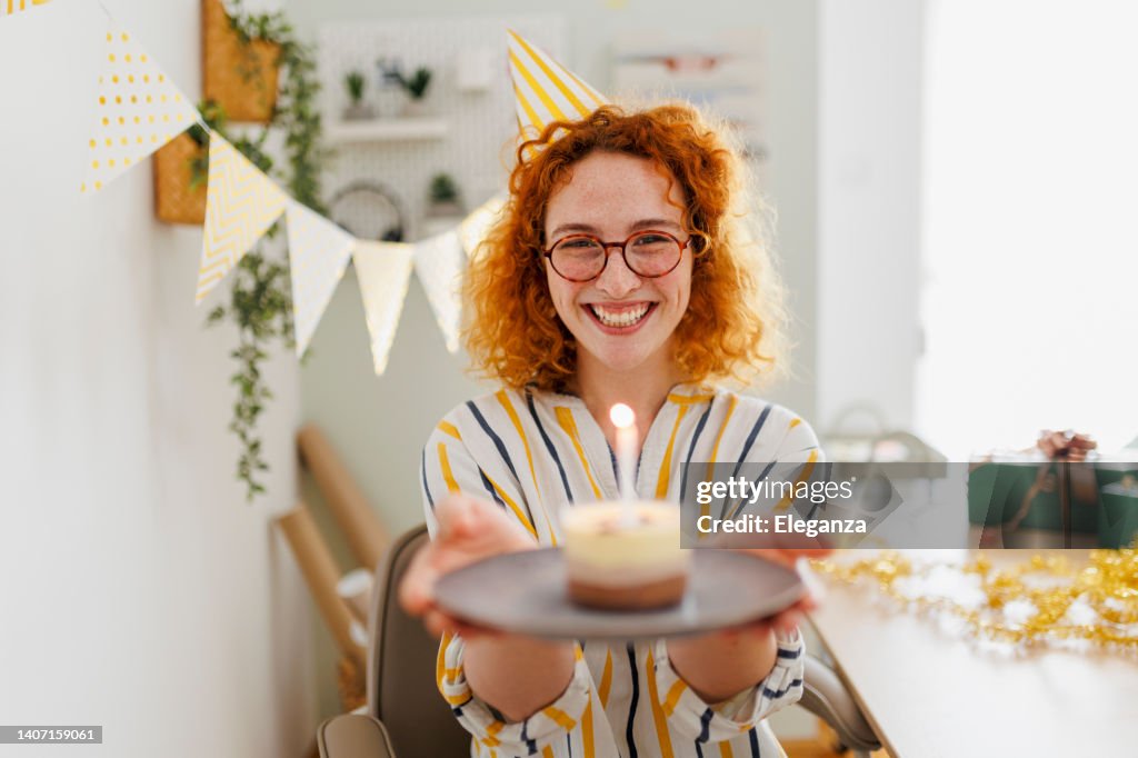 Schöne junge Frau feiert Geburtstag in ihrem Büro