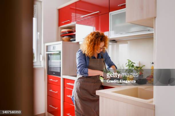 beautiful redhead woman cutting vegetable for salad - chopped stock pictures, royalty-free photos & images