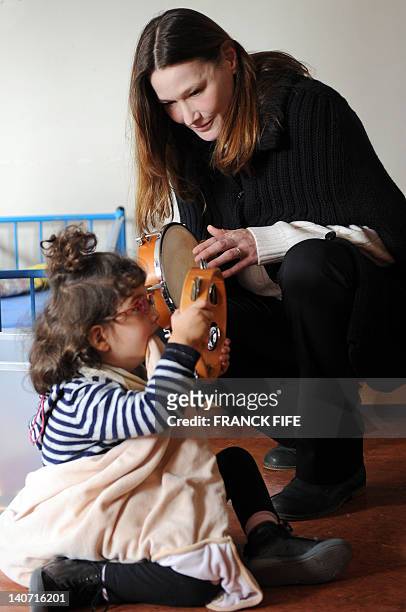 France's First Lady Carla Bruni-Sarkozy is seen with a disabled child on March 5, 2012 as she visits the Motor Reeducation Lapanouse-Debre center for...
