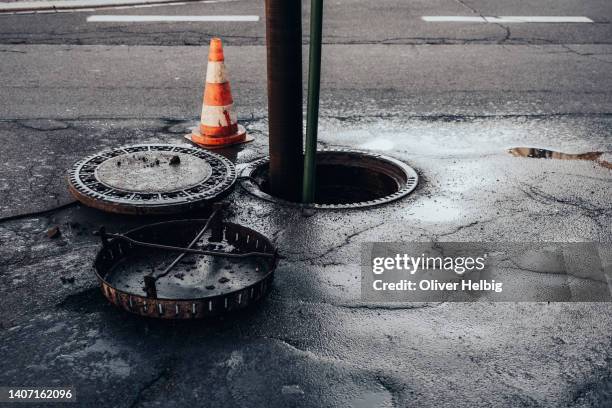 cleaning the sewerage system on a road - riool stockfoto's en -beelden