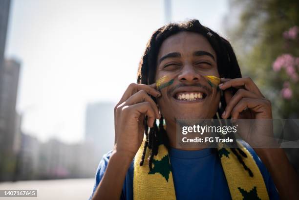 portrait of a young man with painted face - a brazil supporter stockfoto's en -beelden