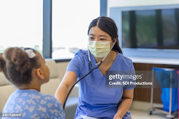nurse smiles through her mask - chinese people in masks stock pictures, royalty-free photos & images