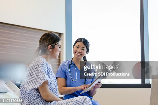 Nurse smiles at her female patient Nurse smiles at her female patient