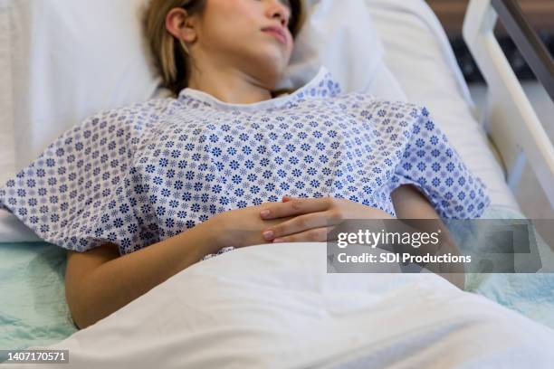 close up photo of female patient laying down - hospital gurney stockfoto's en -beelden