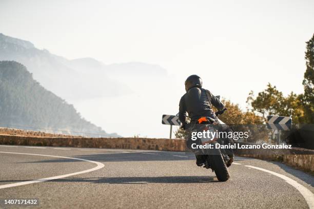 man with riding sport motorbike taking a curve - riding photos et images de collection