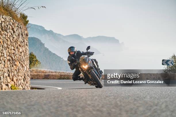 man with riding sport motorbike taking a curve - mare moto foto e immagini stock