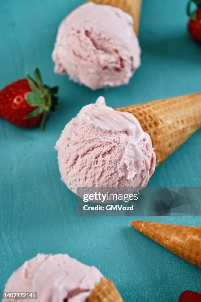 strawberry ice cream in a cone - aardbeienijs stockfoto's en -beelden