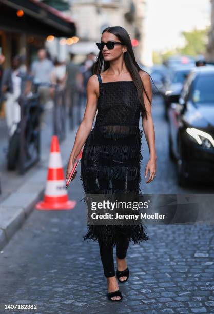 Gabrielle Caunesil Pozzoli seen wearing black sunglasses, silver earrings, a black sequins pattern fringed long dress, a black sequins pattern...