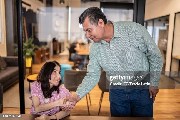 disabled young woman on a handshake with a businessman at work - pact for mexico stock pictures, royalty-free photos & images