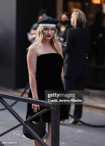 Camille Razat seen wearing a black/white beret hat, a black short tube dress and a black leather rhinestones bag, outside the Giorgio Armani Prive...