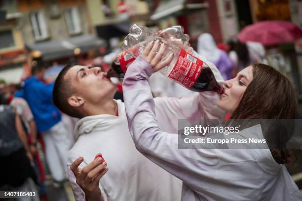 Two people drink coke on a street in Pamplona on the opening day of the San Fermin 2022 festivities, July 6 in Pamplona, Navarra, Spain. The...