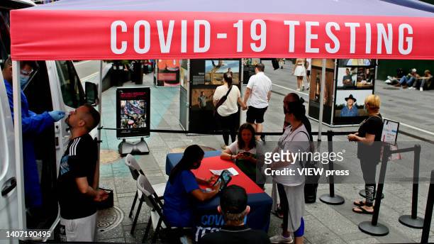 Man is tested at a COVID-19 testing van as persons wait in Times Square, on June 06, 2022 in New York, United States. Parts of Manhattan back at 20%...