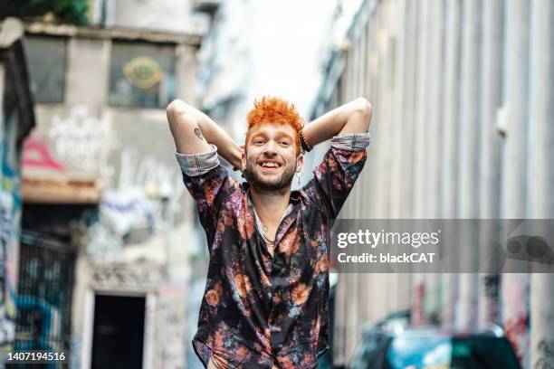 fröhlicher exzentrischer junger mann auf der straße - alternative lifestyle stock-fotos und bilder