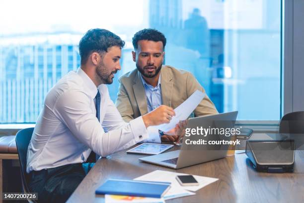 business people working on a document with a laptop and digital tablet - business people and paper imagens e fotografias de stock