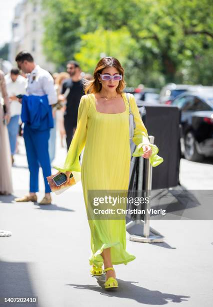 Guest is seen wearing yellow dress with long sleeves, shoes, grey bag outside Elie Saab during Paris Fashion Week - Haute Couture Fall Winter 2022...