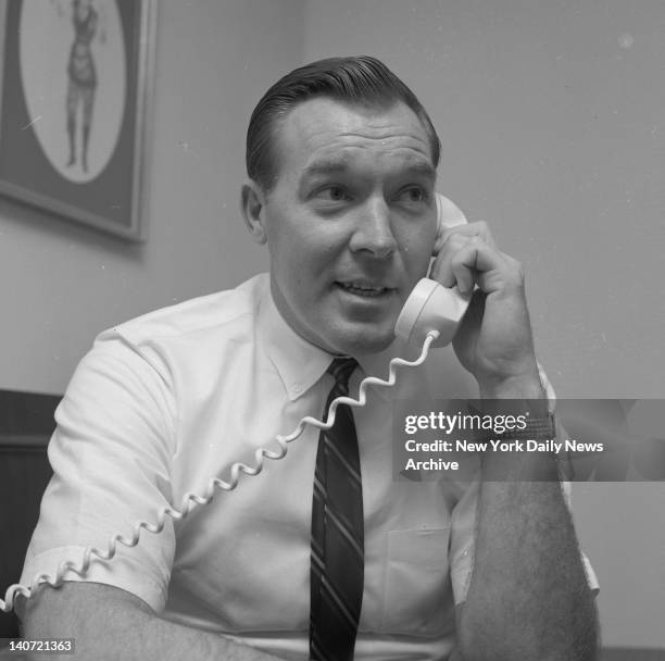Harry Gallatin answers phone at midtown motel and is congratulated by friend after assuming coaching duties of Knicks.