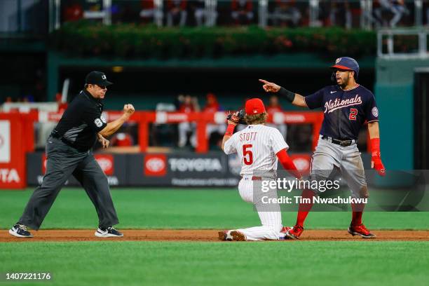 Bryson Stott of the Philadelphia Phillies and Luis Garcia of the Washington Nationals react as umpire Doug Eddings signals Garcia out during the...