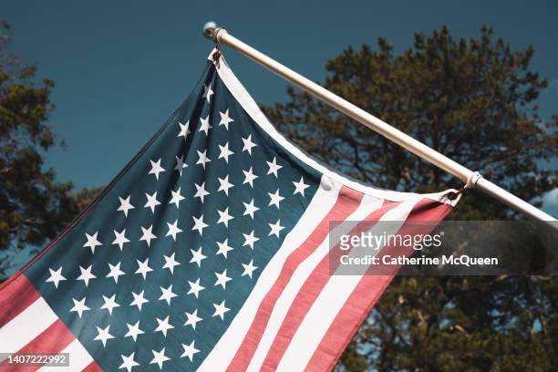 american flag displayed on building exterior - president day stock pictures, royalty-free photos & images