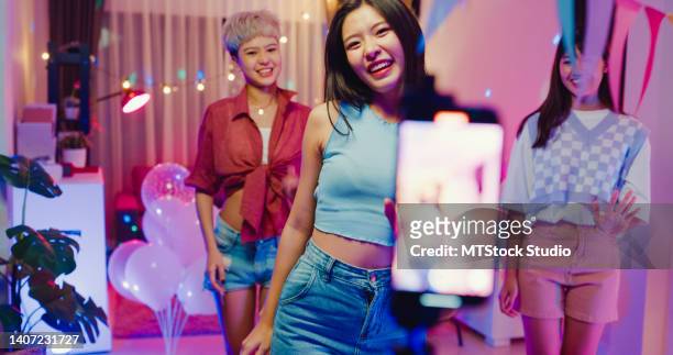 アジアの若い女性の友人tiktokは、夜のカラフルなハウスパーティーで楽しんでいるスマートフォンで彼女のダンスビデオを作成しました。 - very young asian girls ストックフォトと画像