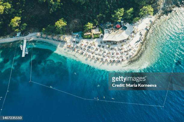 aerial view of turquoise sea, white sand beach with with sun umbrellas. - sandsun stock-fotos und bilder