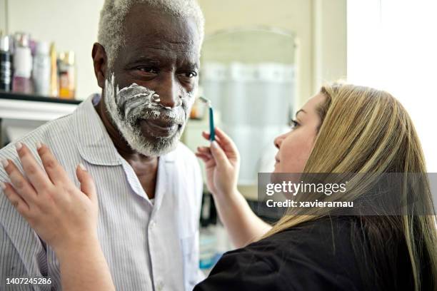 healthcare worker helping senior client with shaving - grooming stock pictures, royalty-free photos & images