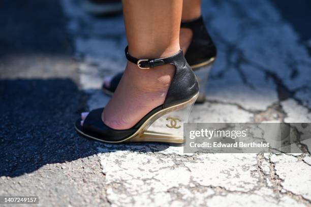 Guest wears a black shiny leather open toe-cap / transparent wedge heels sandals from Chanel, outside Chanel, during Paris Fashion Week - Haute...