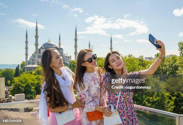 portrait of cheerful girlfriends taking a selfie in front of the blue mosque in istanbul, turkey - daily life in istanbul stock pictures, royalty-free photos & images