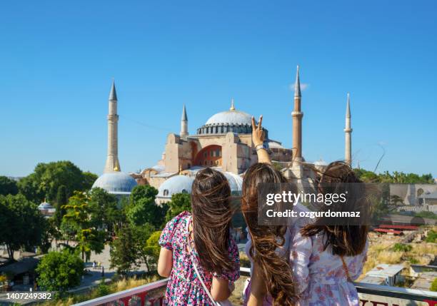 retrato de namoradas alegres posando em frente à mesquita hagia sophia em istambul, turquia - província de istambul - fotografias e filmes do acervo