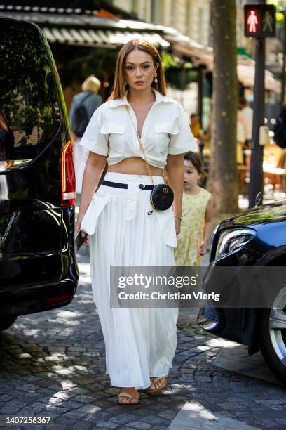 Guest is seen wearing white knotted cropped button shirt, round Dior bag, pleated white high waisted maxi skirt, sandals outside Zuhair Murad during...