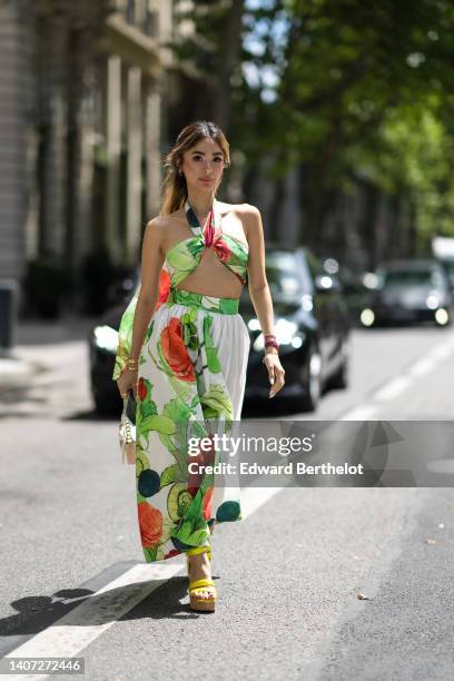 Heart Evangelista wears gold earring, a green / white / red flower print pattern halter-neck / cropped top, a matching green / white / red flower...