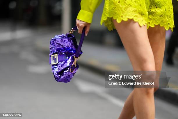 Guest wears a yellow silk shirt, matching yellow lace pattern shorts, a purple shiny sequined handbag from Fendi, outside Elie Saab, during Paris...