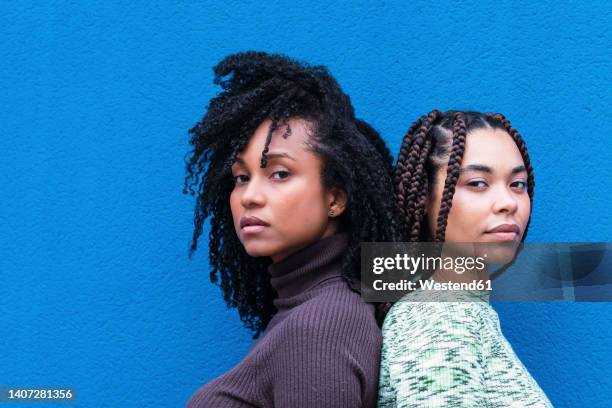 friends standing in front of blue wall - 背對背 個照片及圖片檔