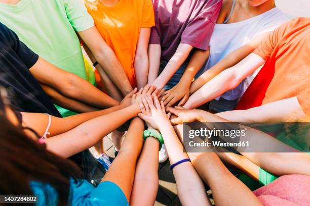 friends stacking hands on sunny day - hand stack stock pictures, royalty-free photos & images