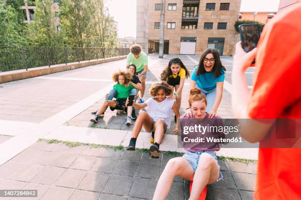 friends enjoying skateboarding together at parking lot - iphone 11 pro stock pictures, royalty-free photos & images