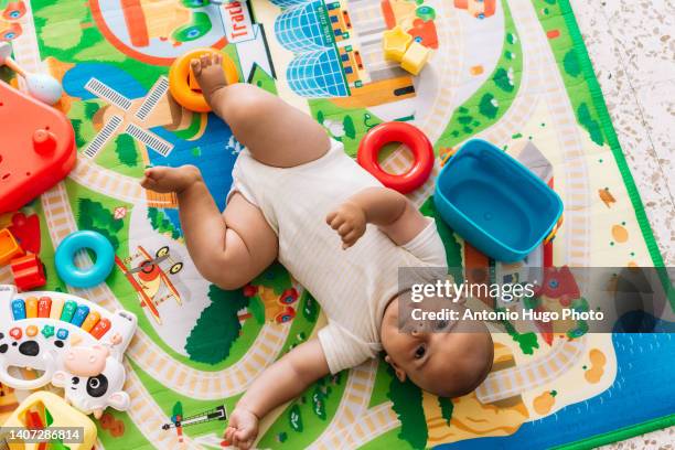 baby lying on a play blanket. seen from above. - clutter stock pictures, royalty-free photos & images