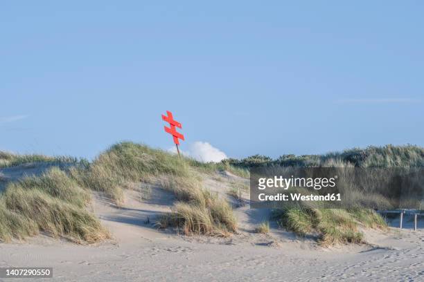 germany, lower saxony, juist, trail post on top of grassy dune - ostfriesiska öarna bildbanksfoton och bilder