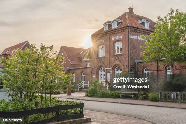 germany, lower saxony, juist, empty town street at sunset with altes warmbad office in background - ostfriesiska öarna bildbanksfoton och bilder