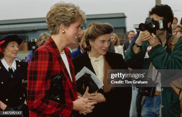 Princess Diana stands beside the Marchioness of Douro Princess Antonia of Prussia surrounded by a crowd of people at a Guinness Trust Project in...