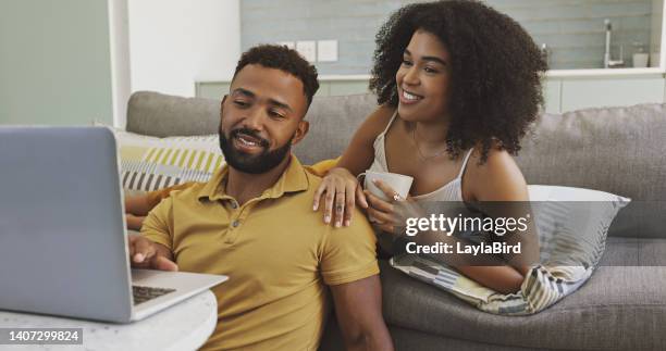 couple browsing online using a laptop together at home. boyfriend and girlfriend looking at funny videos on a computer. husband and wife searching internet and watching movies. man and woman using pc - couple searching the internet stock pictures, royalty-free photos & images