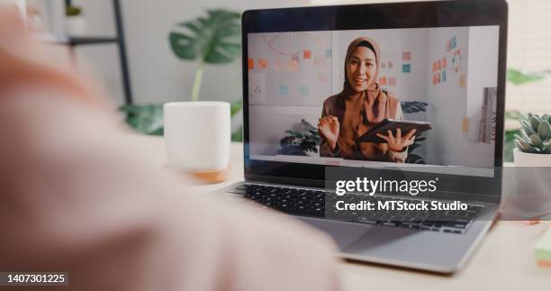 close up of young asian woman using laptop making video call with customer while working in office. - business zoom stock pictures, royalty-free photos & images