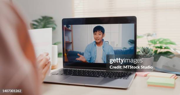 close up of young asian woman using laptop making video call with customer while working in office. - office space movie stock pictures, royalty-free photos & images