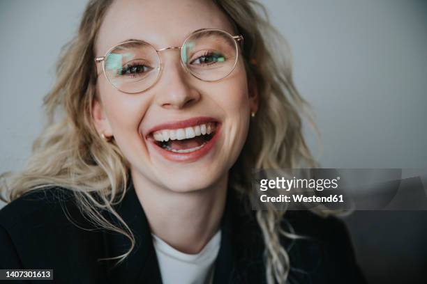 blond businesswoman laughing wearing eyeglasses - middelste deel stockfoto's en -beelden