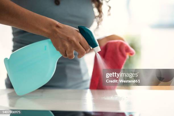 hand of woman cleaning table at home spraying water - spray bottle stock pictures, royalty-free photos & images