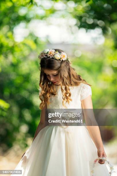 girl wearing communion dress in forest - communion fotografías e imágenes de stock